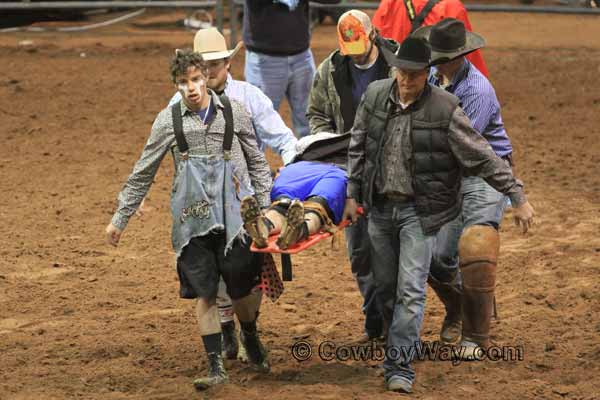 A rodeo bullfighter gets carried out of the arena on a stretcher