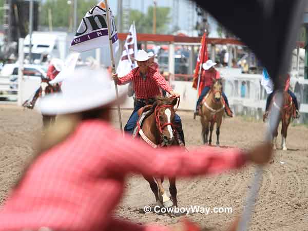 Cheyenne Dandies crossing in front 
of the bucking chutes