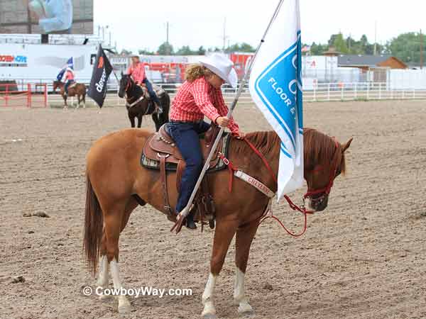 A Cheyenne Dandie dips her flag in respect to the flag of the United States 
of America