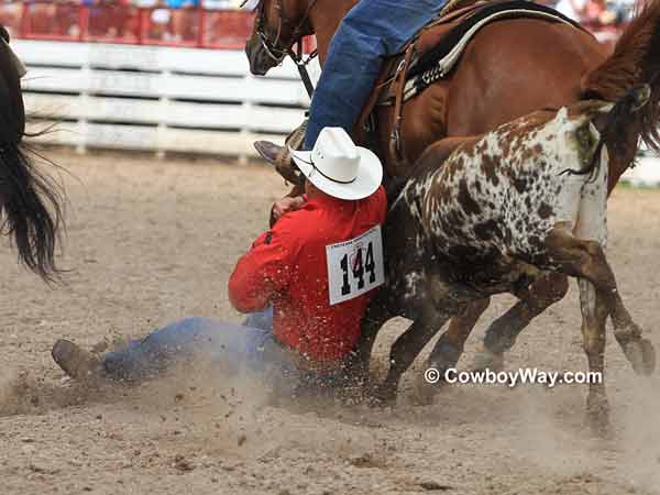 A steer wrestler gets down on his steer