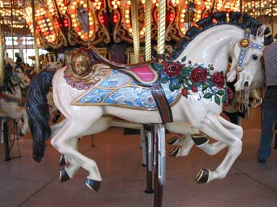 A carousel horse with a blue bridle and saddle pad