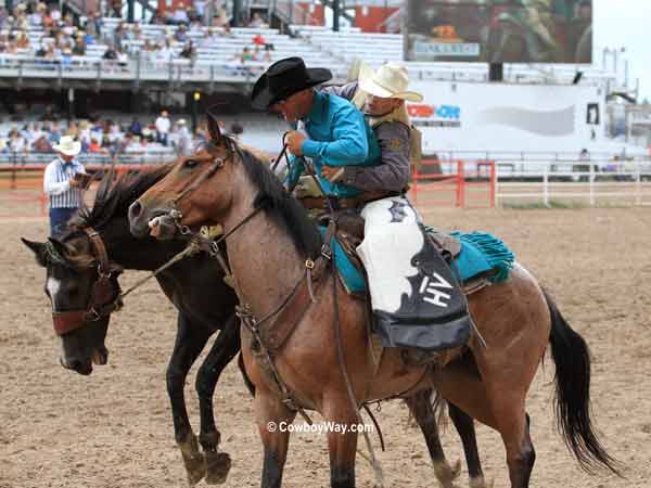 Saddle bronc rider Dusty Hausauer gets off on a pickup man