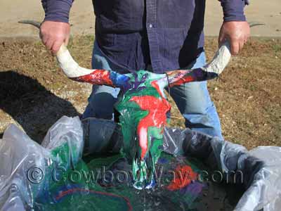 A red and green painted cow skull