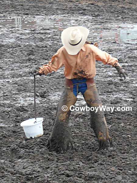 A cowgirl looks down at herself and all the mud