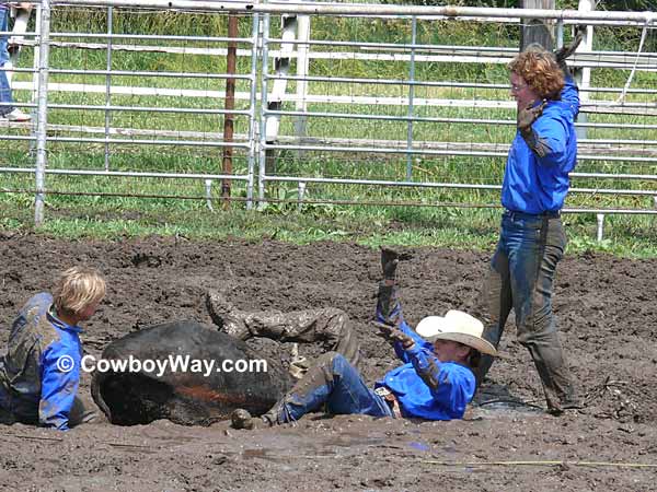 Three cowgirls finish tying their steer