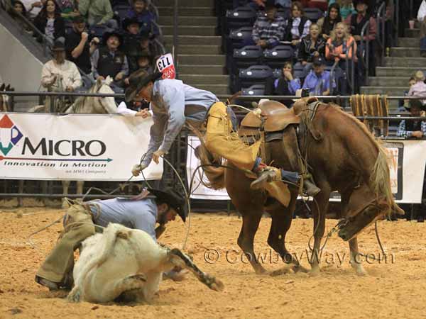 A rider jumps off of a bucking horse