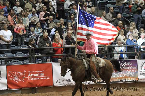 Chris Potter carrying the flag at the WRCA ranch rodeo Finals